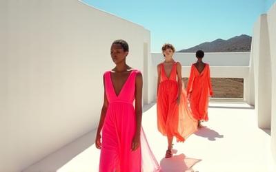 Jacquemus runway show with models in vibrant, flowing fabrics on a Mediterranean-inspired set